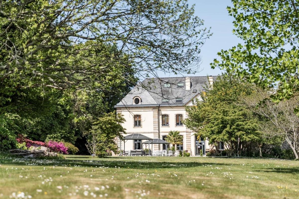 une grande maison blanche avec des arbres et de l'herbe dans l'établissement Manoir des Indes, The Originals Relais, à Quimper