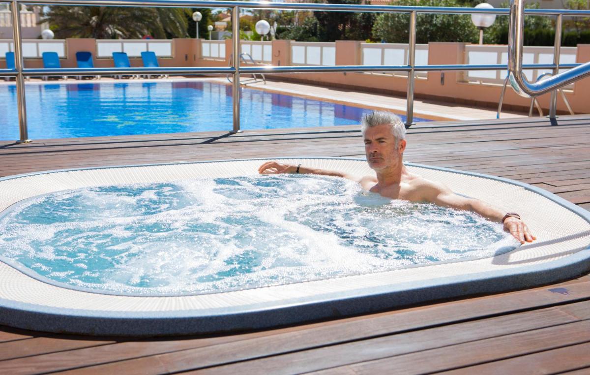 un hombre en un jacuzzi en una piscina en Poseidon La Manga Hotel & Spa - Designed for Adults, en La Manga del Mar Menor