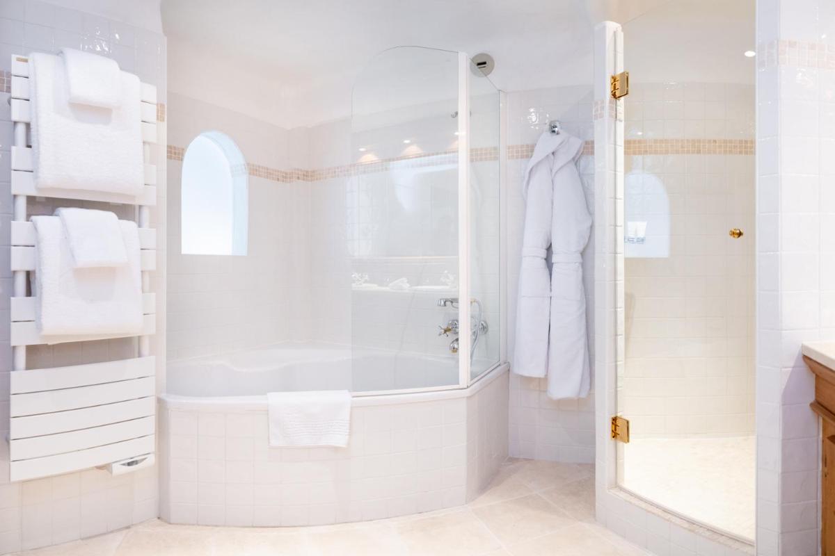 une salle de bain blanche avec une douche et un lavabo dans l'établissement Grand Hôtel Courchevel 1850, à Courchevel