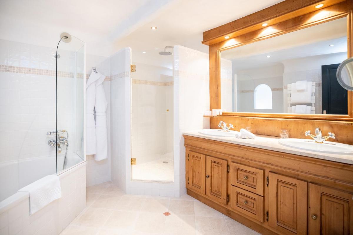une salle de bain avec un lavabo, une douche et un miroir dans l'établissement Grand Hôtel Courchevel 1850, à Courchevel 37 autres photos