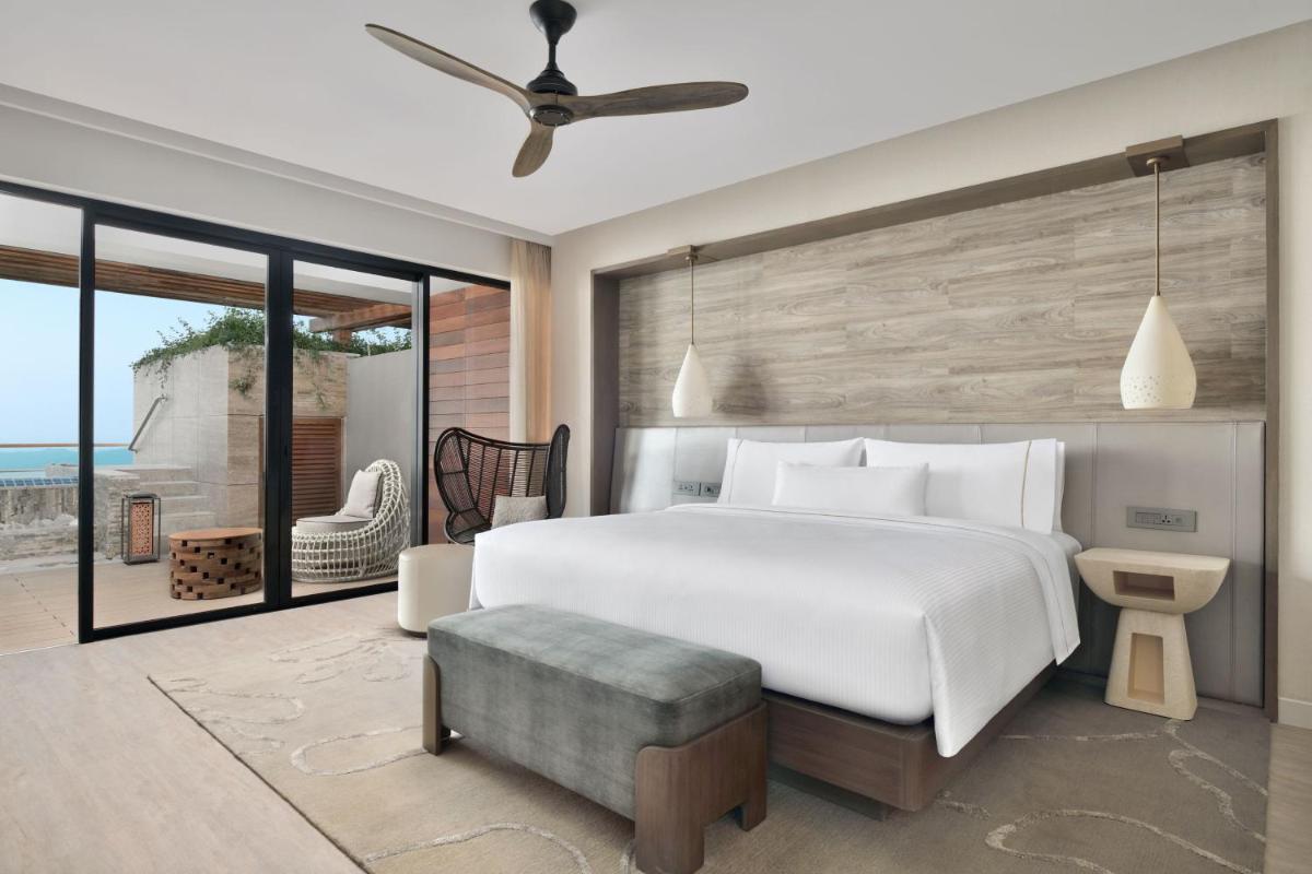 a bedroom with a large white bed and a patio at The Westin Resort & Spa Himalayas in Rishīkesh