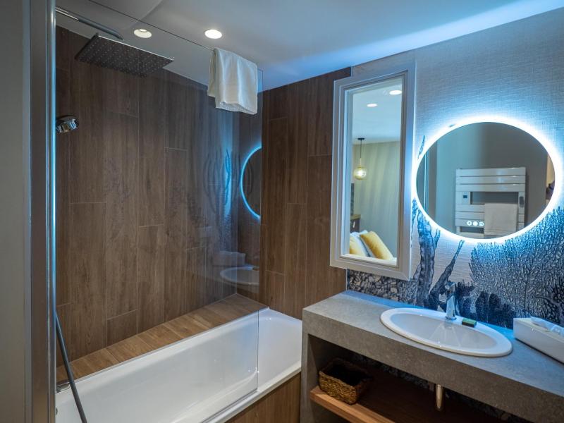 une salle de bain avec une baignoire, un lavabo et un miroir dans l'établissement HOTEL LA MARINE, à Groix