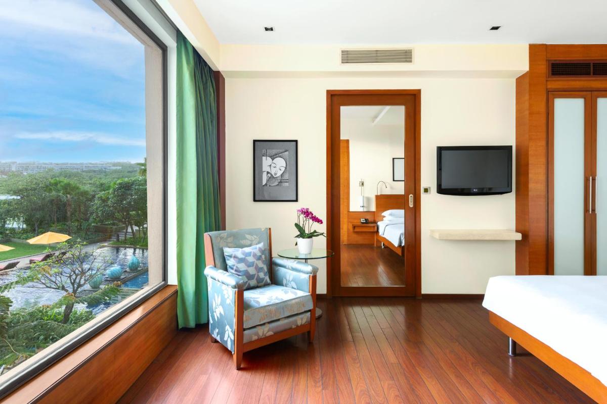 a bedroom with a bed and a large window at Hyatt Pune in Pune