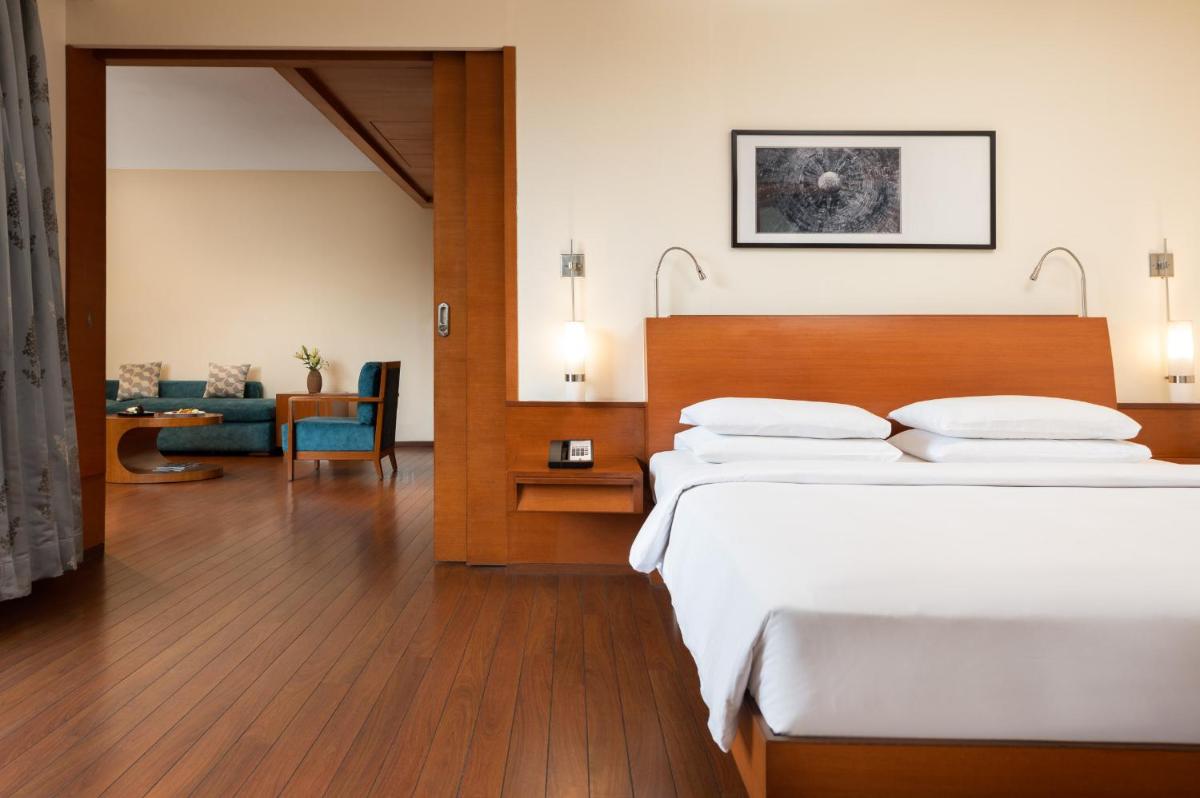 a hotel room with a bed and a living room at Hyatt Pune in Pune