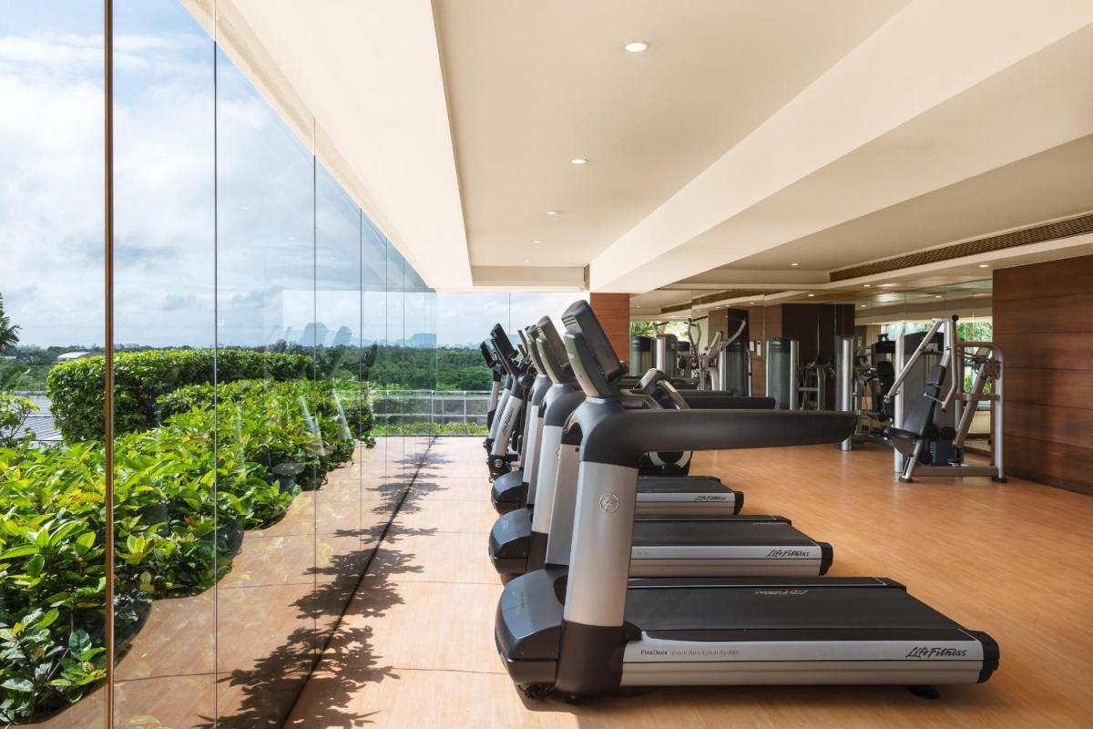 a row of treadmills in a gym with windows at Hyatt Pune in Pune