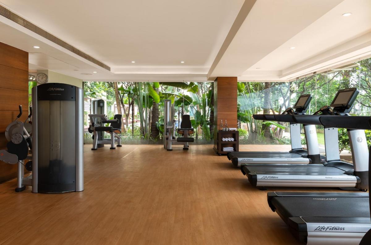 a gym with a row of treadmills and machines at Hyatt Pune in Pune