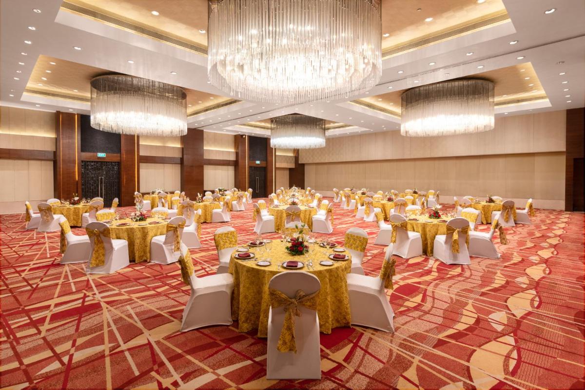 a large banquet hall with tables and chairs and chandeliers at Hyatt Pune in Pune