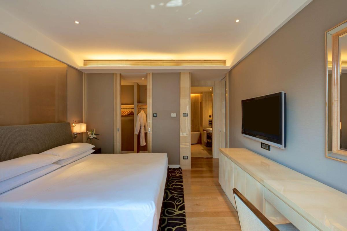 a hotel room with two beds and a flat screen tv at Hyatt Regency Pune Hotel & Residences in Pune