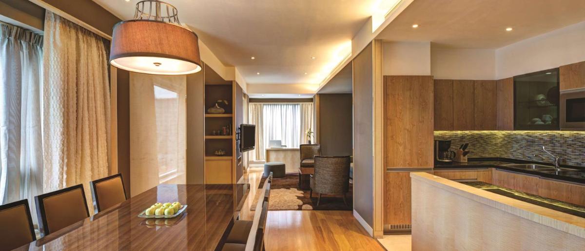 a kitchen with a wooden counter and a dining table at Hyatt Regency Pune Hotel & Residences in Pune