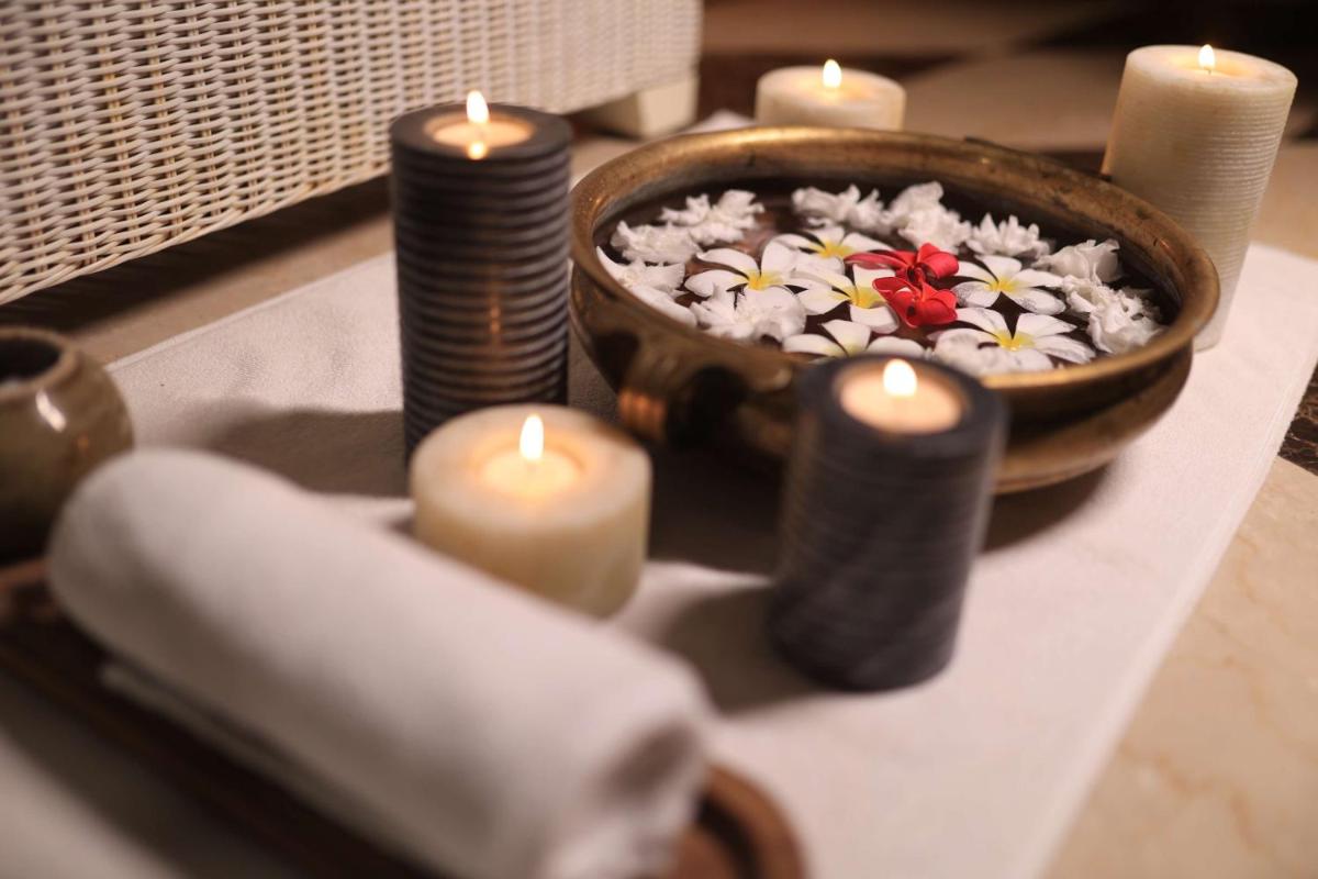 a table with candles and a bowl of flowers at Hyatt Regency Pune Hotel & Residences in Pune