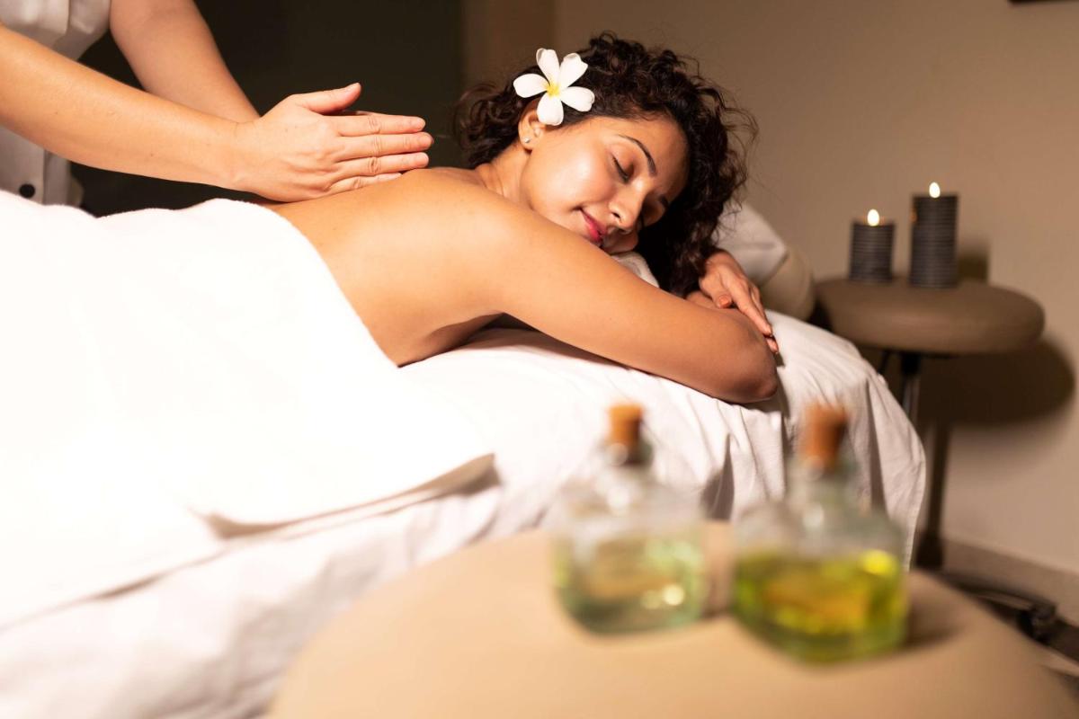 a woman getting a back massage in a salon at Hyatt Regency Pune Hotel & Residences in Pune