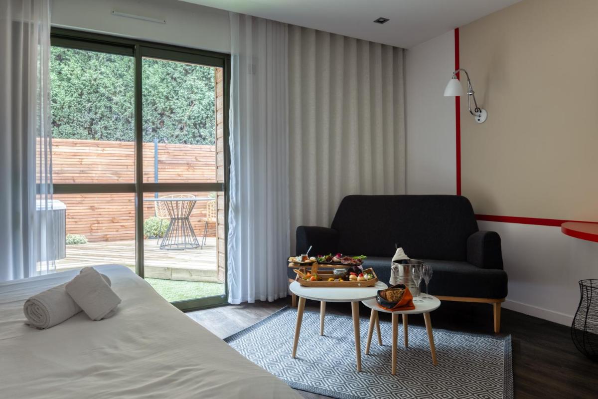 une chambre avec un lit, une table et une chaise dans l'établissement Logis Hôtel Domaine du Moulin Cavier - Restaurants & Spa, à Avrillé