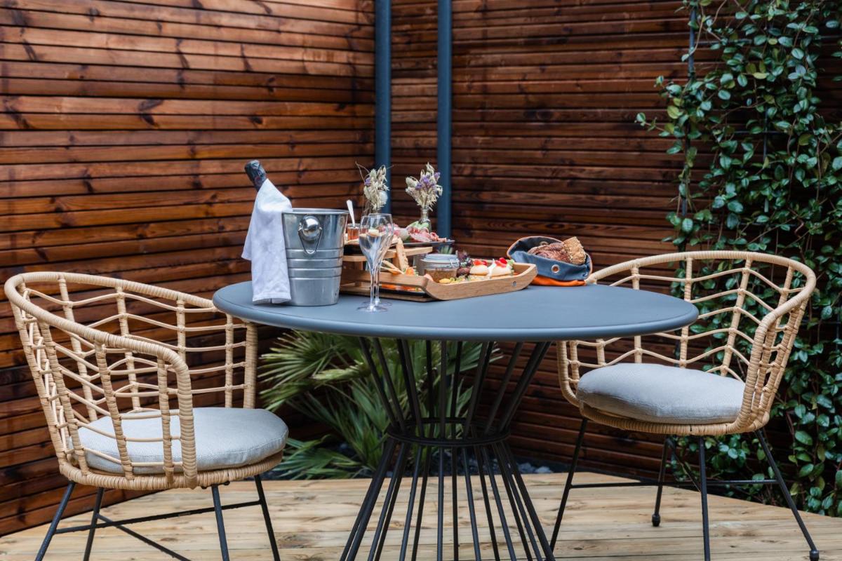 une table avec deux chaises et une table avec de la nourriture dessus dans l'établissement Logis Hôtel Domaine du Moulin Cavier - Restaurants & Spa, à Avrillé