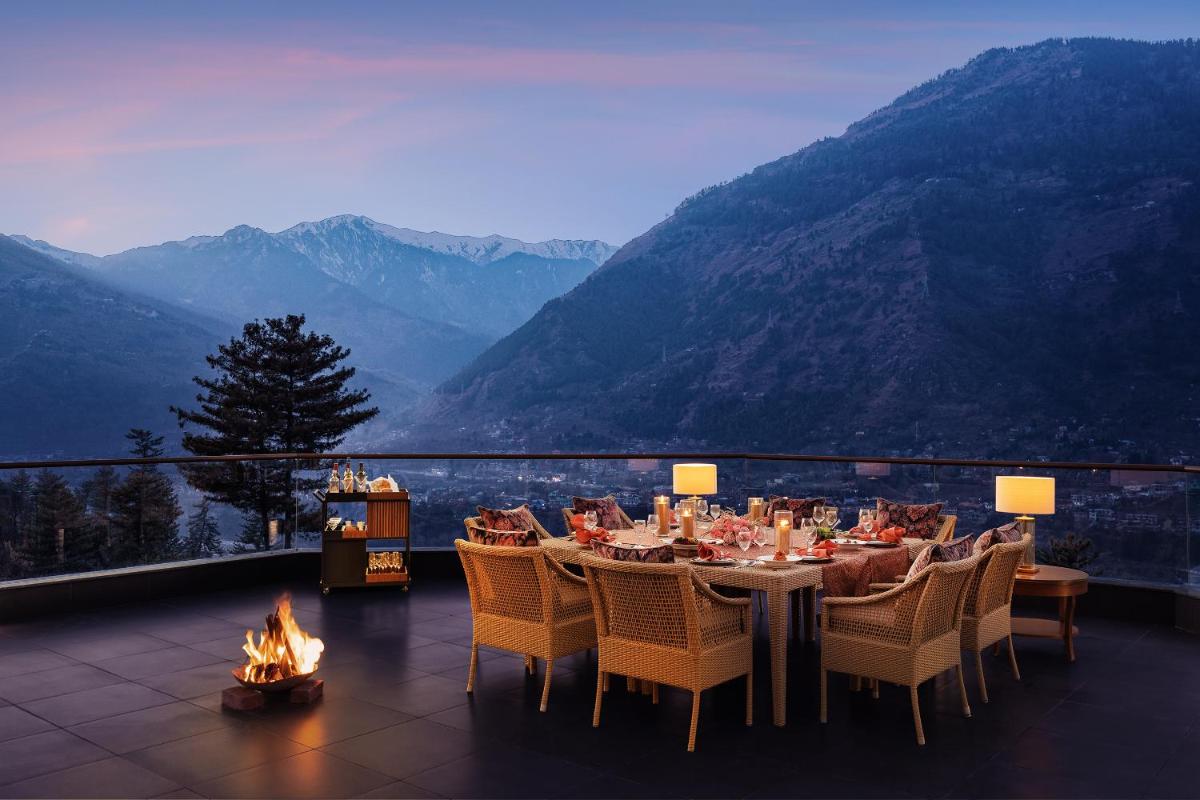 a dining room with a table and a view of mountains at Baragarh Resort & Spa, Manali- IHCL SeleQtions in Manāli