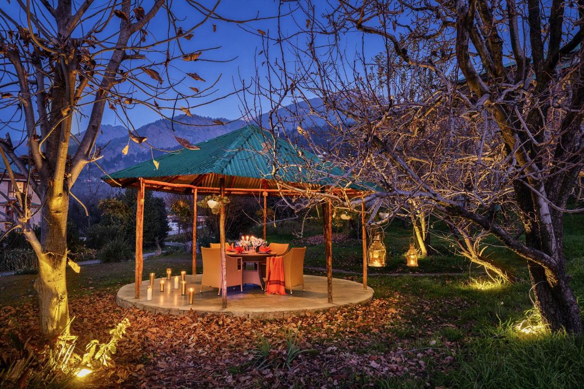 a gazebo with a table in a garden at night at Baragarh Resort & Spa, Manali- IHCL SeleQtions in Manāli