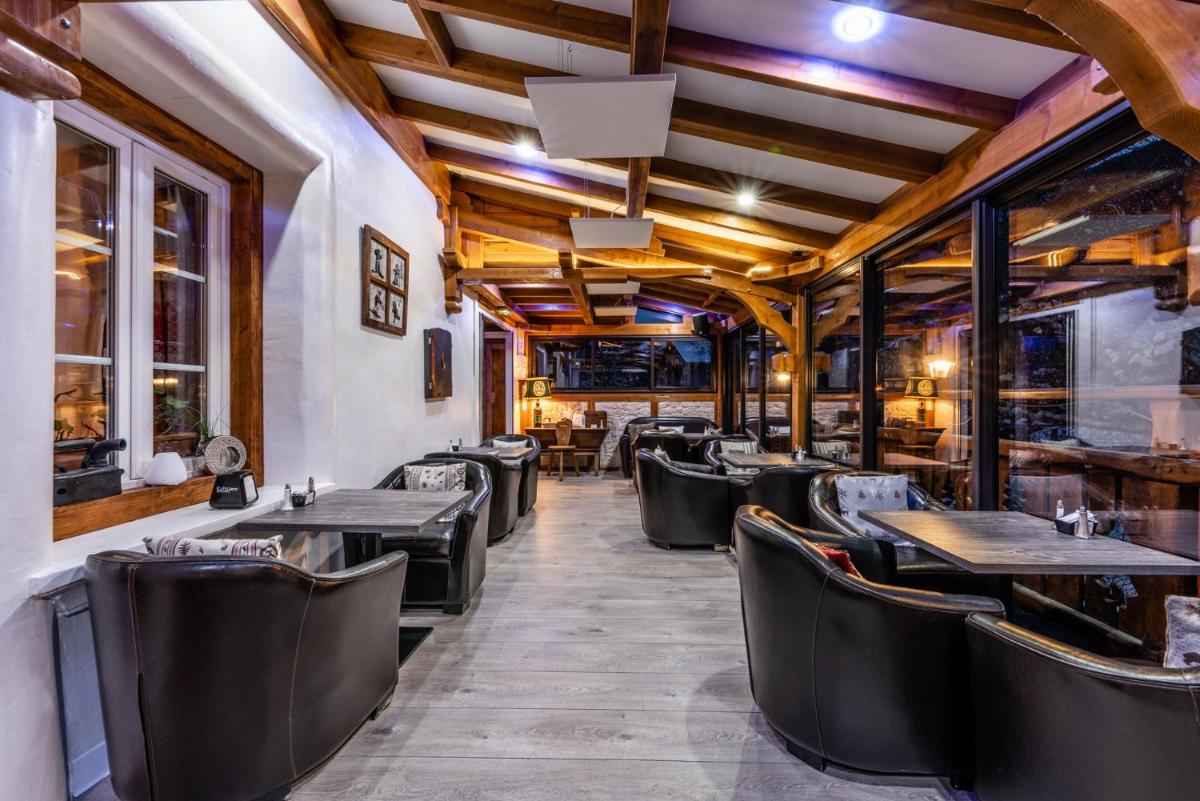 une rangée de tables et de chaises dans un restaurant dans l'établissement Logis Hôtel et Spa Le Christiania, à La Salle Les Alpes