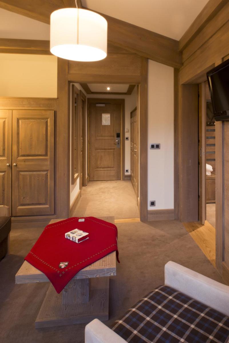 un salon avec une couverture rouge sur une table dans l'établissement Hotel le Petit Dru, à Morzine