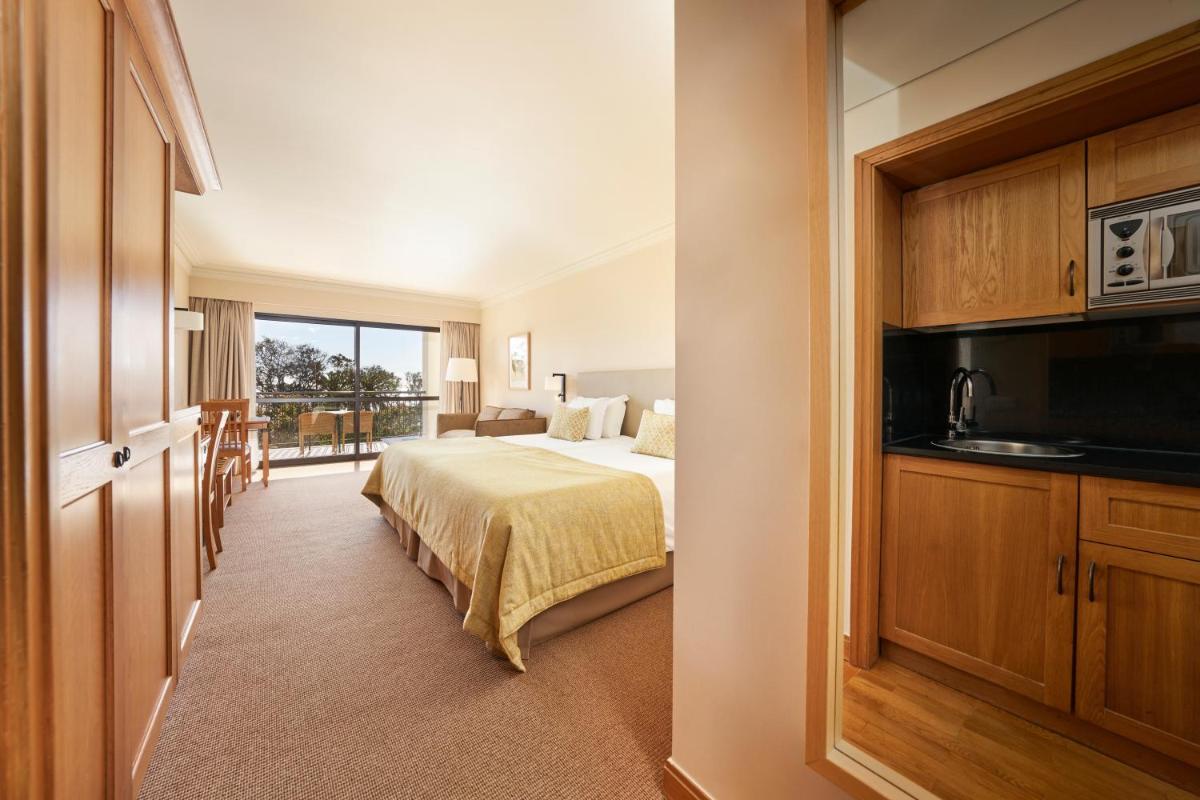 um quarto de hotel com uma cama e uma varanda em The Residence Porto Mare - PortoBay no Funchal mais 44 fotografias