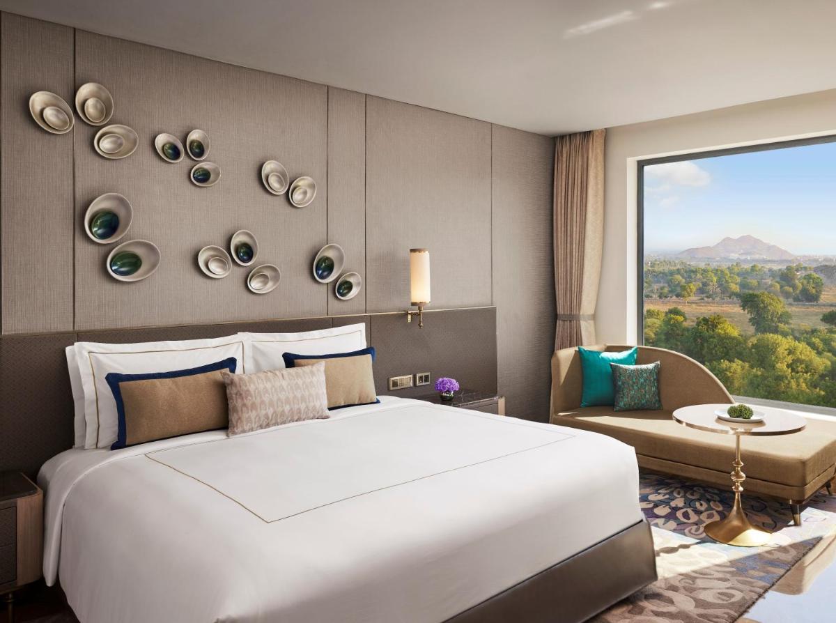 a bedroom with a large white bed and a window at Taj Amer, Jaipur in Jaipur