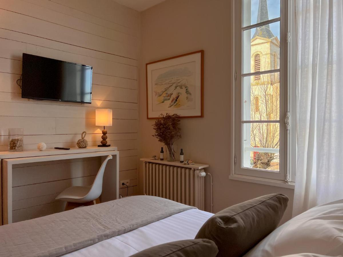 une chambre avec un lit, un bureau et une fenêtre dans l'établissement Le Chat Botté, à Saint-Clément-des-Baleines