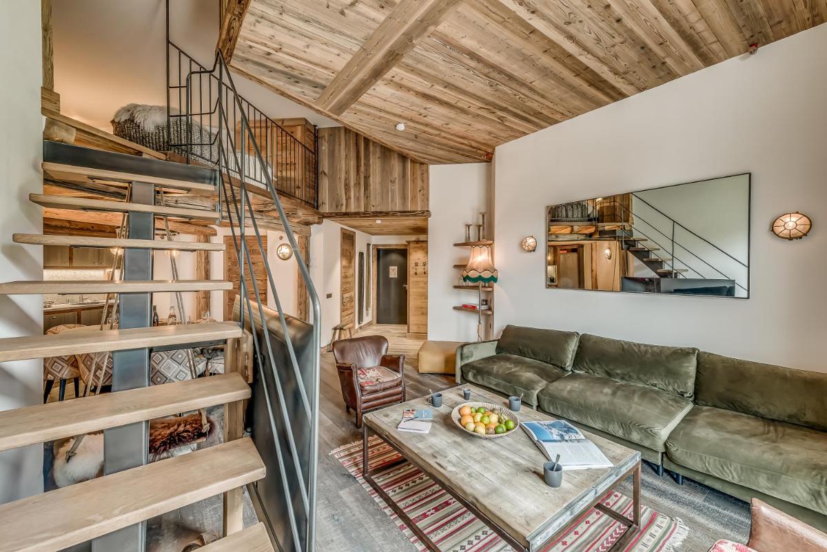 un salon avec un canapé et une table dans l'établissement Hotel & Spa Le Val d'Isère, à Val dʼIsère