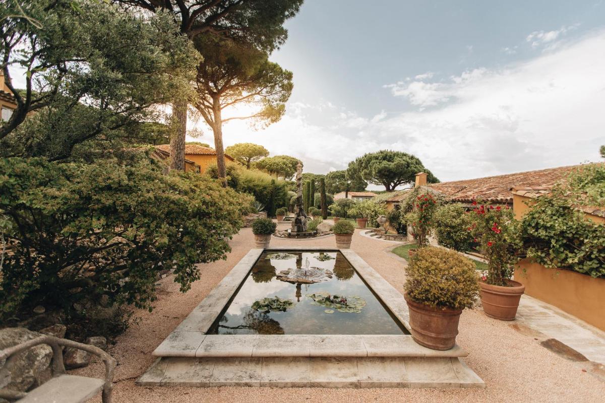 un jardin avec un étang, des arbres et des plantes dans l'établissement Hôtel Villa Marie Saint Tropez, à Saint-Tropez