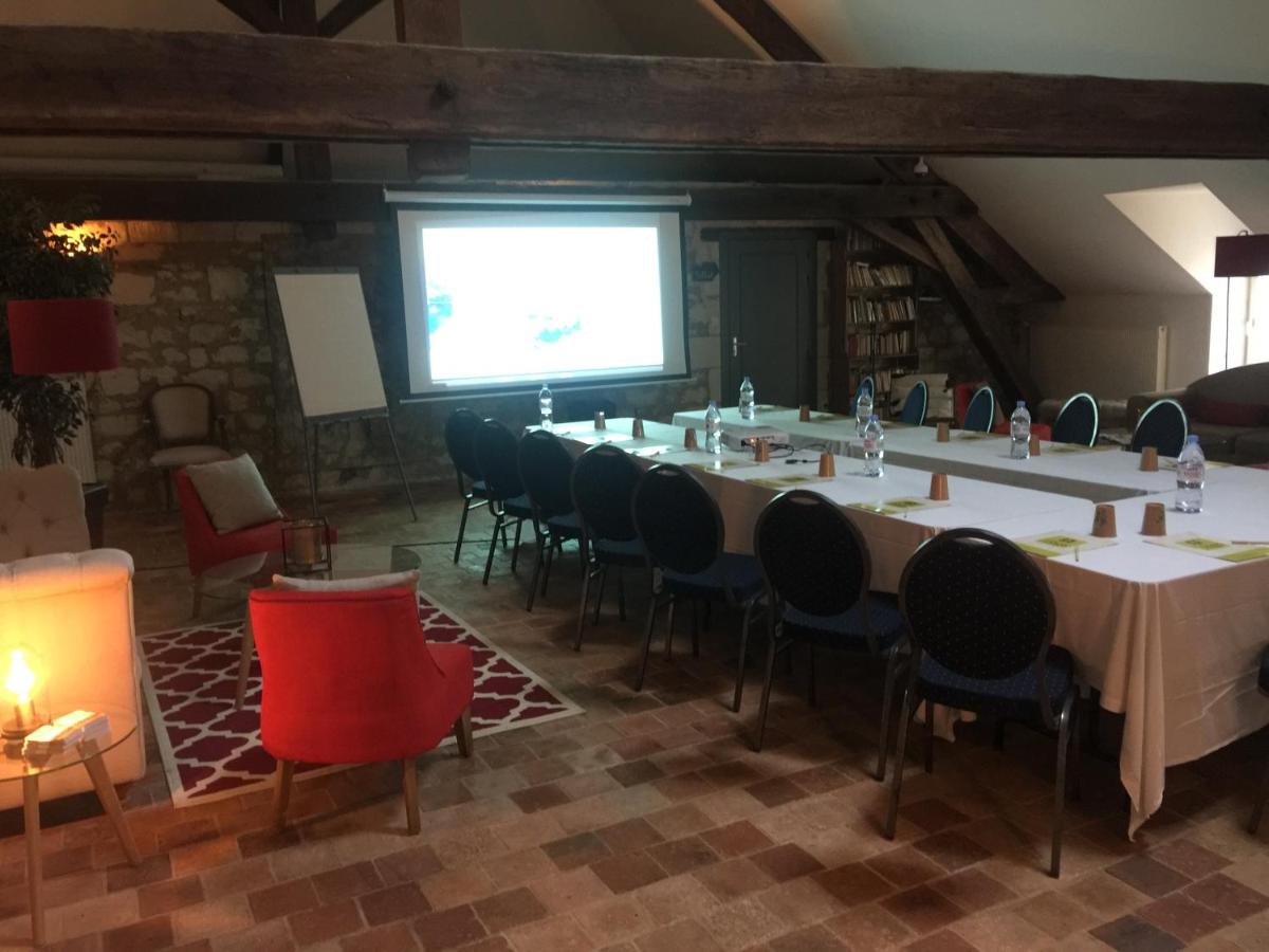 une grande salle de réunion avec une longue table et des chaises dans l'établissement Hôtel & Spa Chai De La Paleine, à Le Puy-Notre-Dame