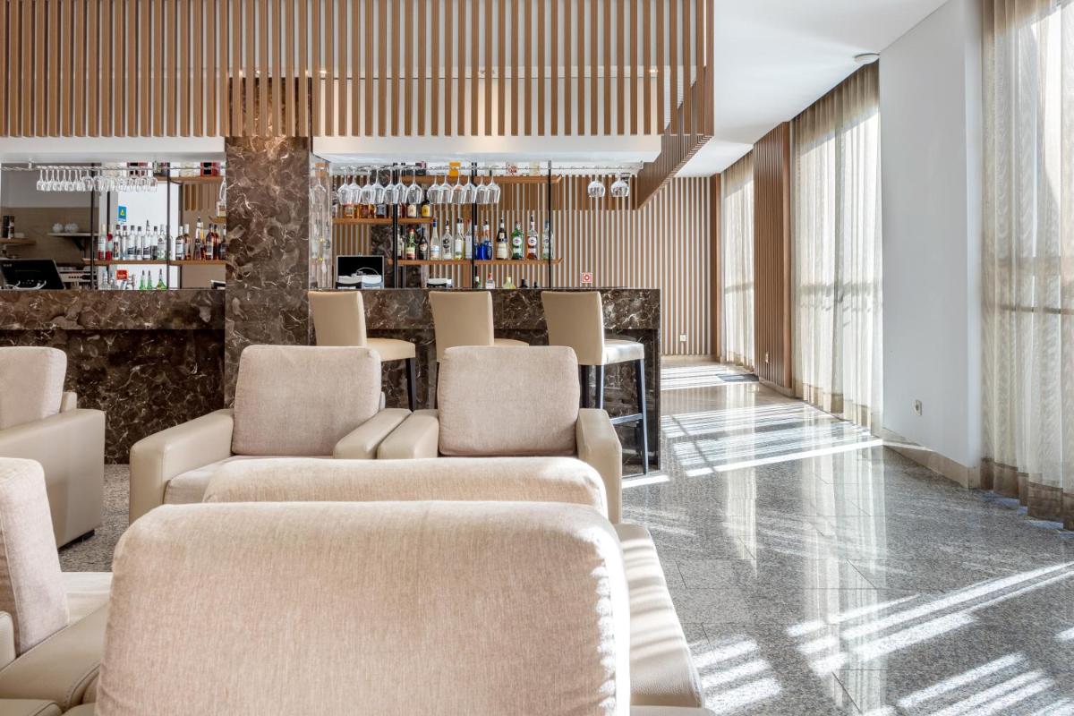 um saguão com sofás e um bar em Hotel Porta do Sol Conference & SPA em Caminha