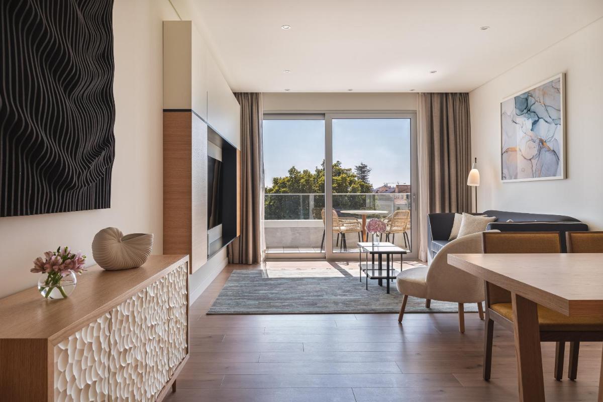 uma sala de estar com uma mesa de jantar e uma sala de estar com vista em Hyatt Regency Lisbon em Lisboa