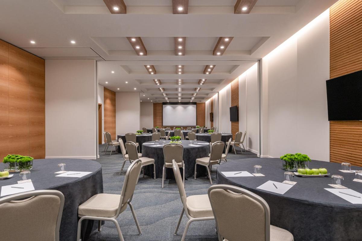 uma sala de conferências com mesas e cadeiras e uma tela em Hyatt Regency Lisbon em Lisboa mais 126 fotografias