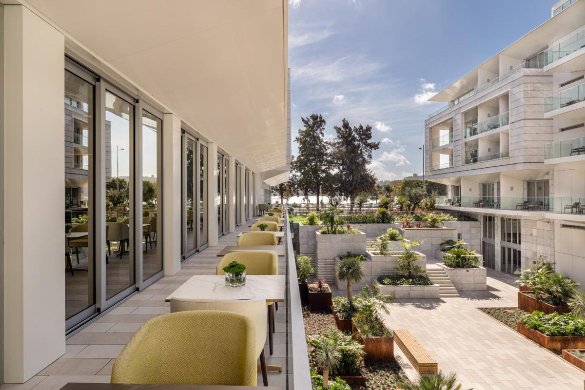um pátio exterior com cadeiras e mesas num edifício em Hyatt Regency Lisbon em Lisboa