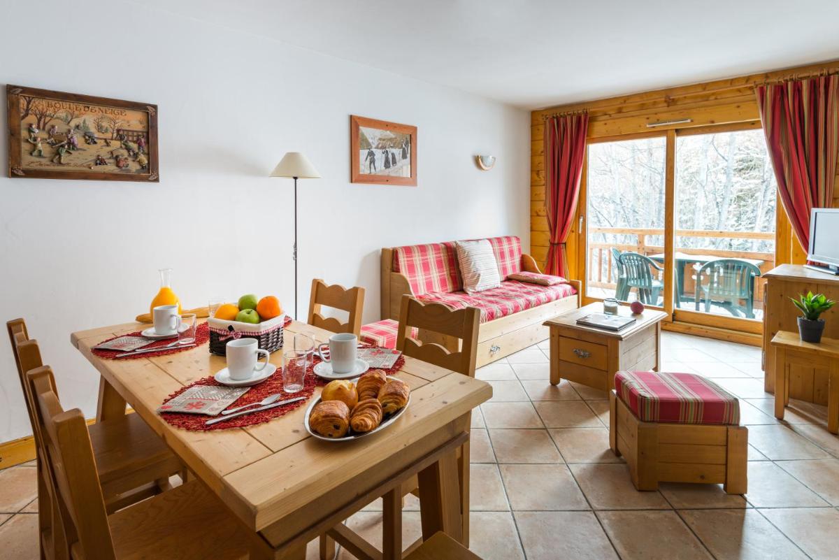 un salon avec une table avec de la nourriture dessus dans l'établissement Lagrange Vacances Le Hameau du Rocher Blanc, à Saint-Chaffrey