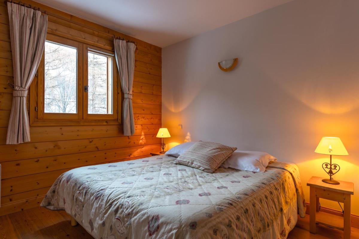 - une chambre avec un lit avec deux lampes et deux fenêtres dans l'établissement Lagrange Vacances Le Hameau du Rocher Blanc, à Saint-Chaffrey 15 autres photos