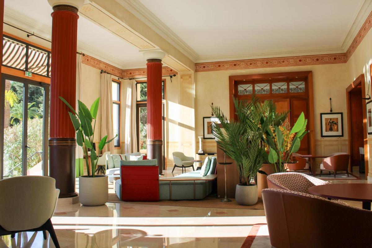 un hall d'entrée avec des tables, des chaises et des plantes dans l'établissement Hotel Royal-Riviera, à Saint-Jean-Cap-Ferrat