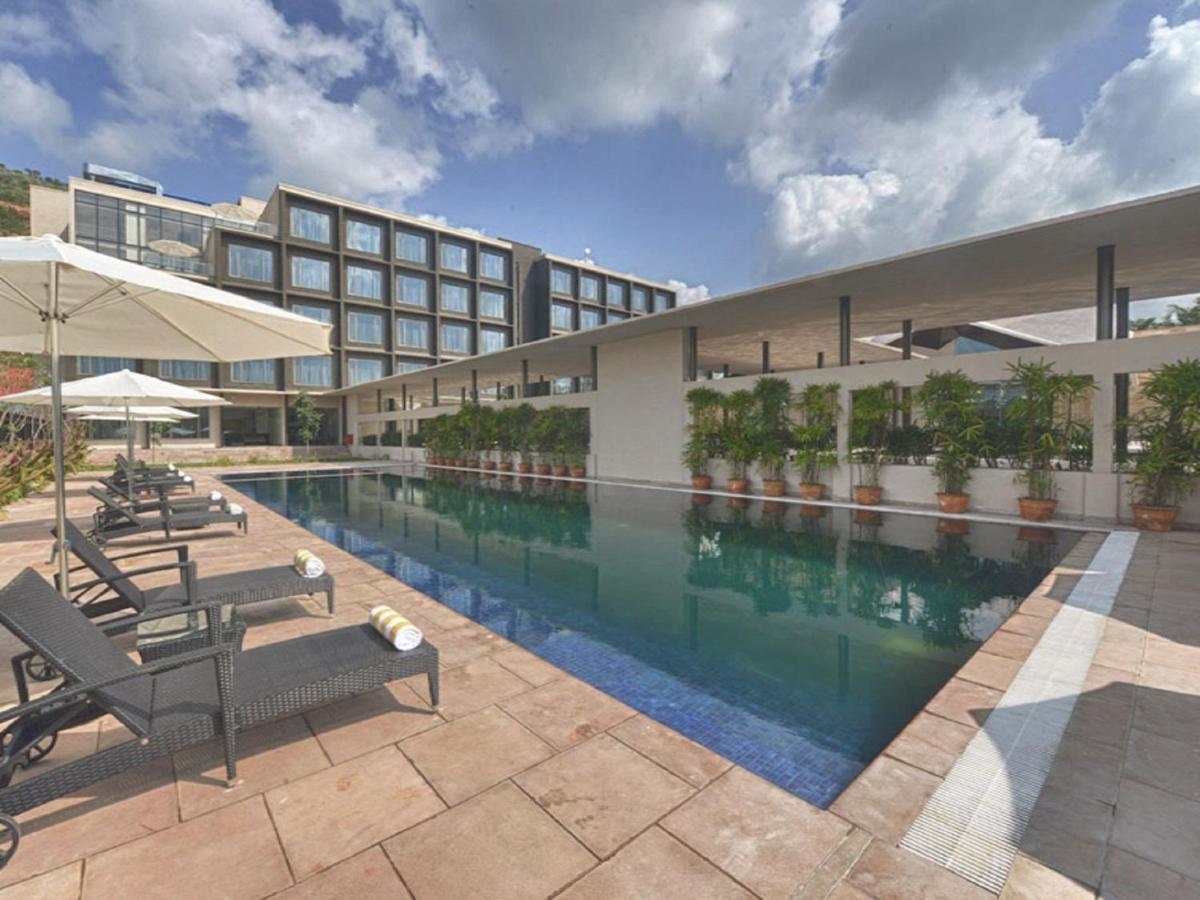 a hotel with a swimming pool in front of a building at Marasa Sarovar Premiere in Tirupati
