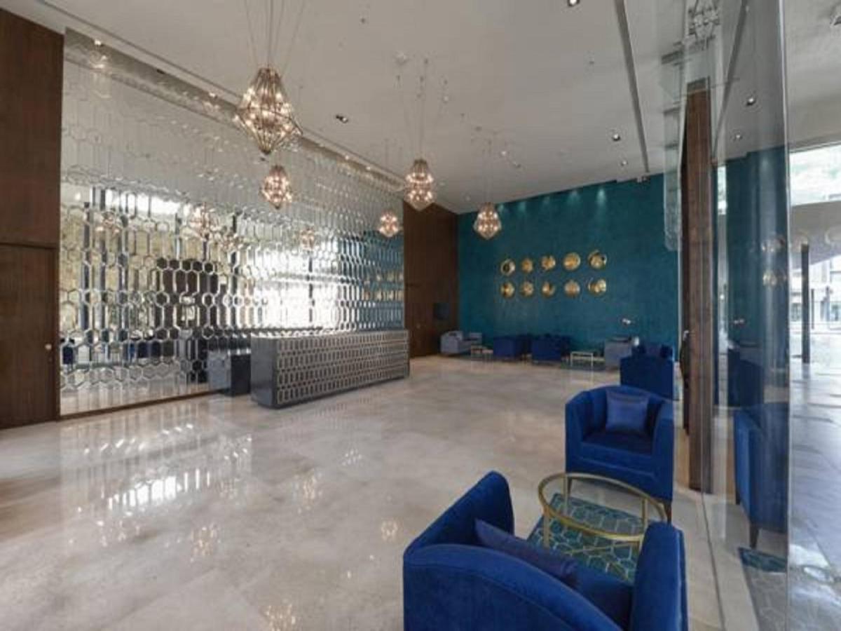 a large room with blue chairs and a wall at Marasa Sarovar Premiere in Tirupati