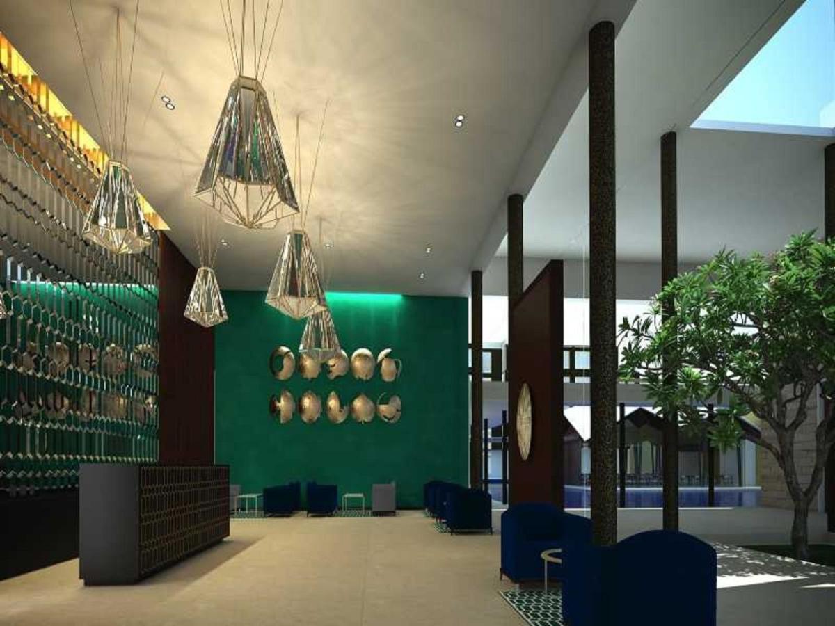 a lobby with a green wall and chandeliers at Marasa Sarovar Premiere in Tirupati