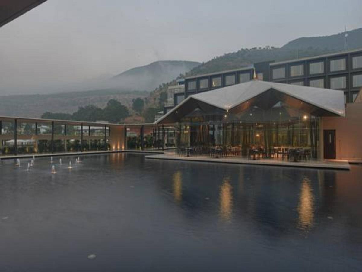 a building with a pool of water with tables and chairs at Marasa Sarovar Premiere in Tirupati