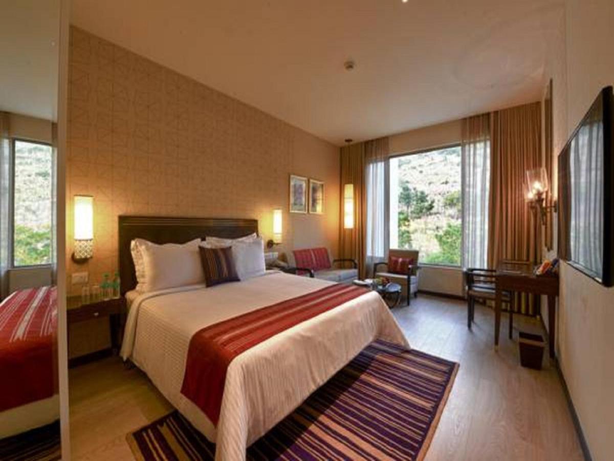 a hotel room with a bed and a living room at Marasa Sarovar Premiere in Tirupati