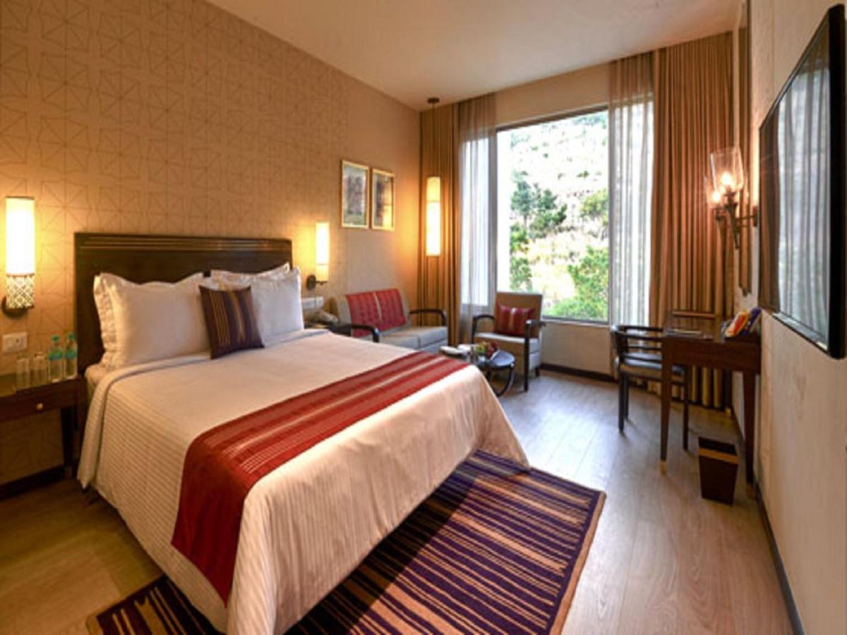 a hotel room with a bed and a large window at Marasa Sarovar Premiere in Tirupati +43 photos