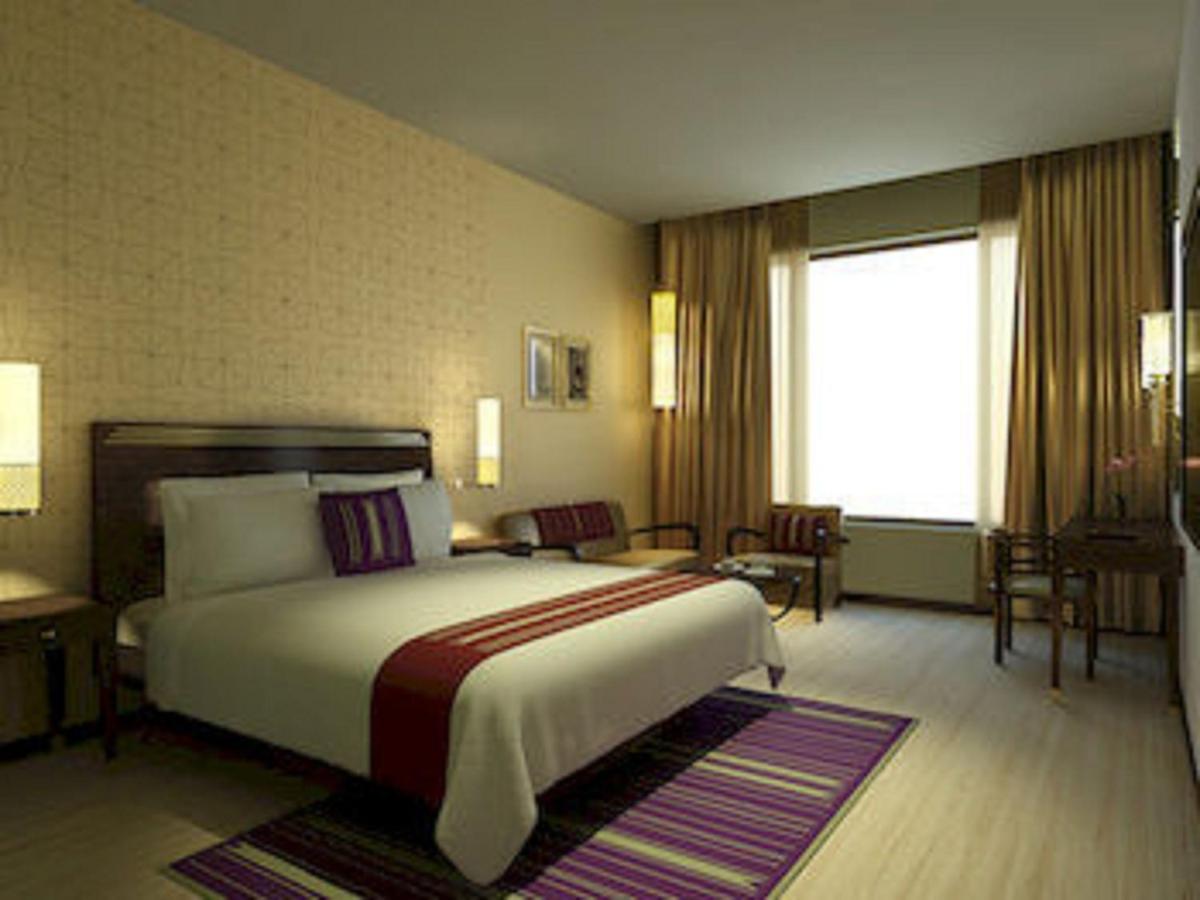 a hotel room with a bed and a window at Marasa Sarovar Premiere in Tirupati