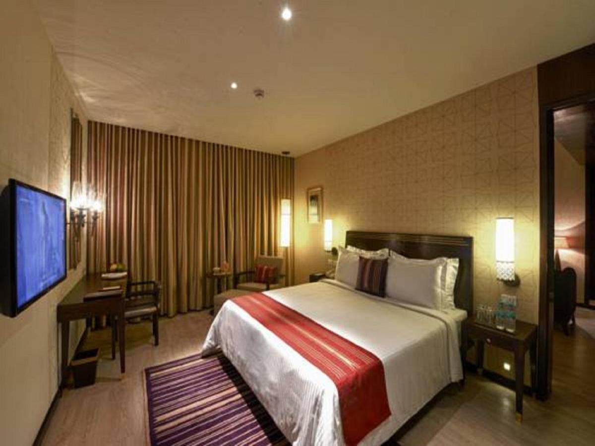 a hotel room with a bed and a television at Marasa Sarovar Premiere in Tirupati