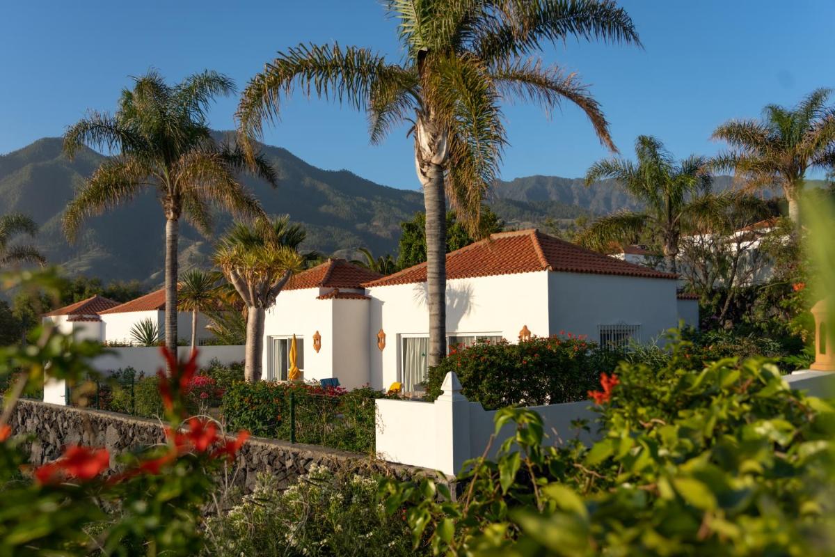 una casa con palmeras y montañas en el fondo en La Palma Jardín Resort, en El Paso