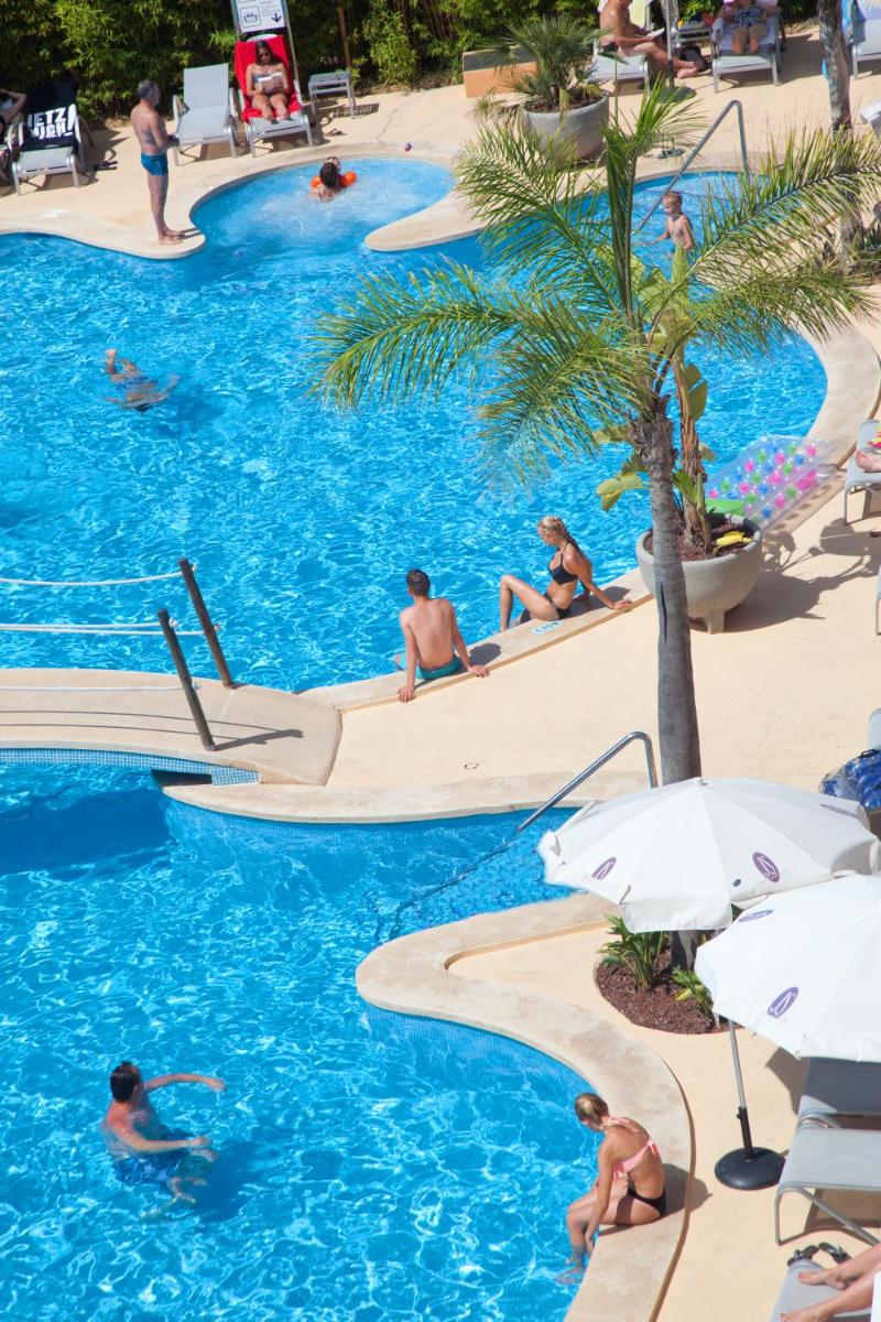 Un grupo de personas en la piscina de un resort. en JS Alcudi-Mar, en Playa de Muro