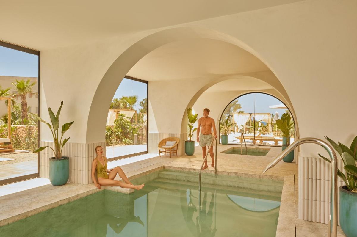 Un hombre y una mujer sentados en una piscina en The Signature Level at TRS Ibiza Hotel - All Inclusive Adults Only - Entrance to Clubs included, en San Antonio