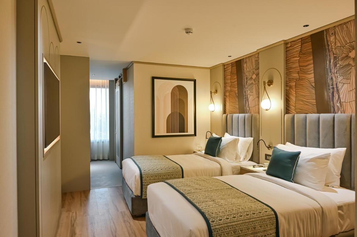 a hotel room with two beds and a hallway at Parallel Hotel Udaipur, a member of Radisson Individuals in Udaipur