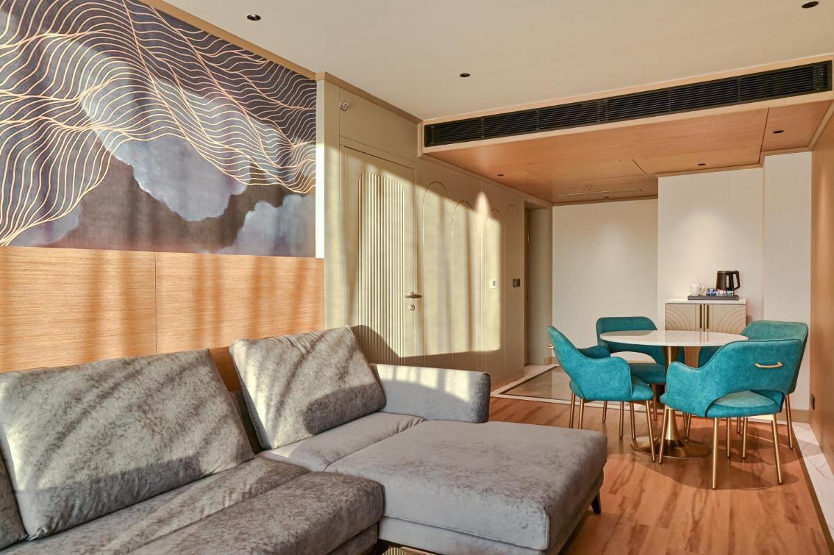 a living room with a couch and a table and chairs at Parallel Hotel Udaipur, a member of Radisson Individuals in Udaipur