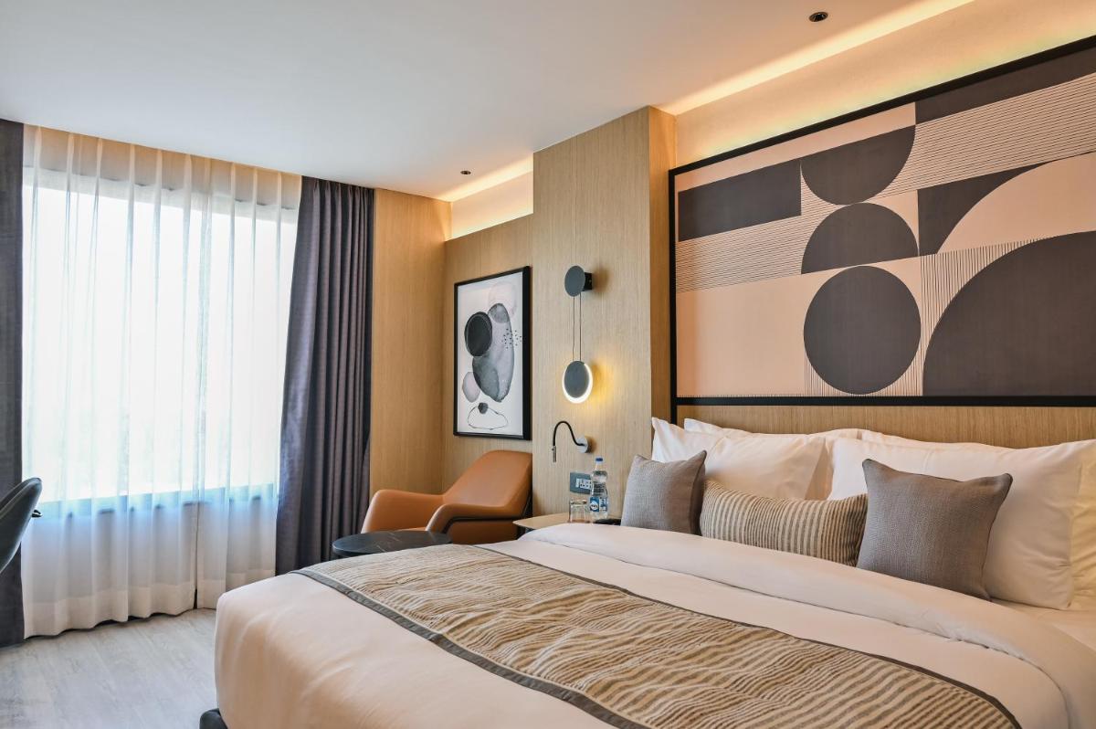 a hotel room with a large bed and a chair at Parallel Hotel Udaipur, a member of Radisson Individuals in Udaipur