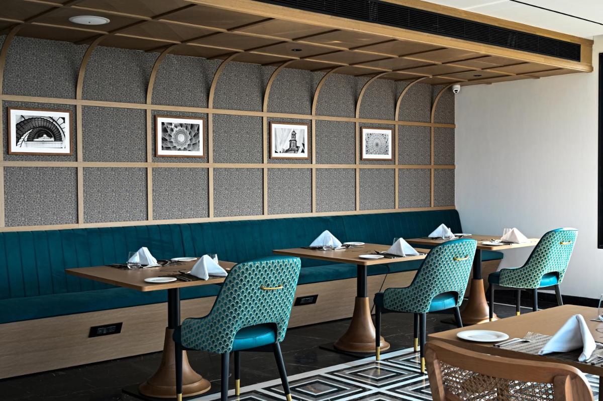 a dining room with tables and chairs and pictures on the wall at Parallel Hotel Udaipur, a member of Radisson Individuals in Udaipur