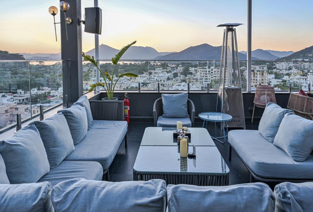 a rooftop bar with couches and a view of the city at Parallel Hotel Udaipur, a member of Radisson Individuals in Udaipur